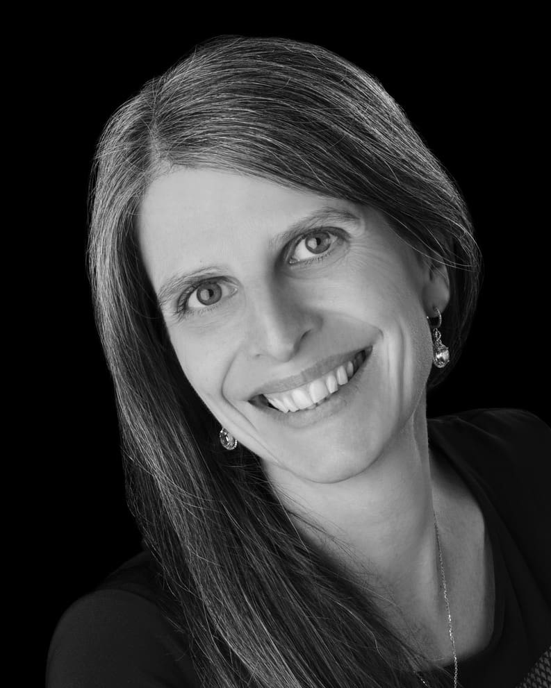 A black and white photo of a woman smiling.