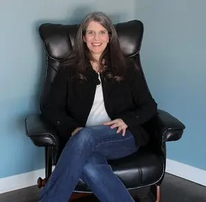 A woman sitting in a black leather chair.