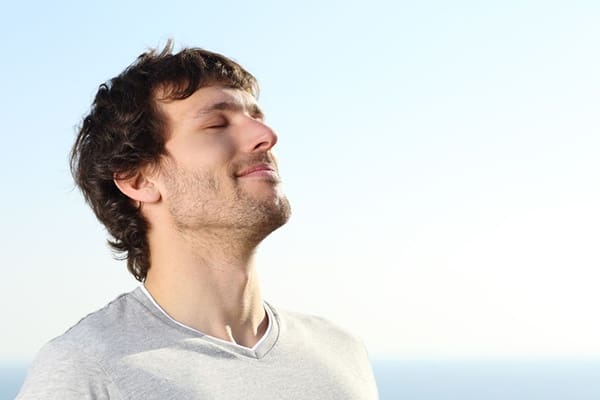 A man with his eyes closed and hands in the air.