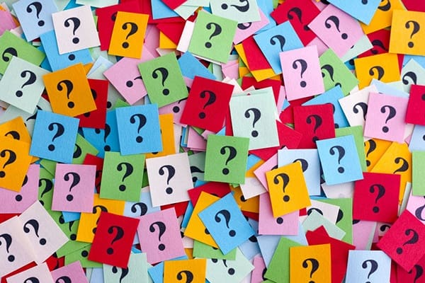 A pile of colorful paper with question marks on them.