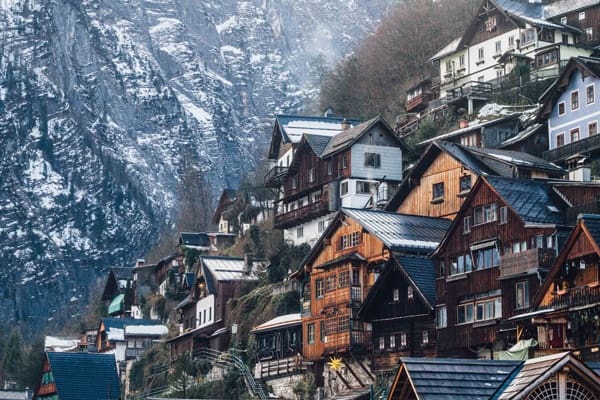 A painting of a mountain village with snow on the top.