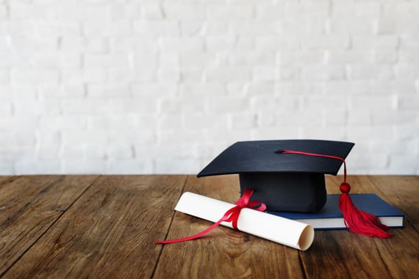 A graduation cap and diploma on top of a table.