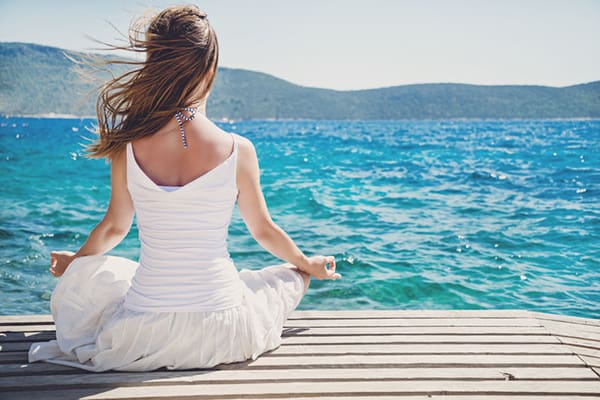 A woman sitting on the dock of water