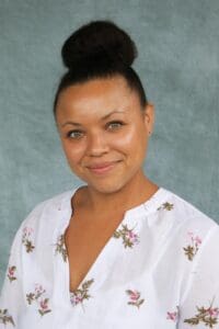 A woman with a bun and white shirt